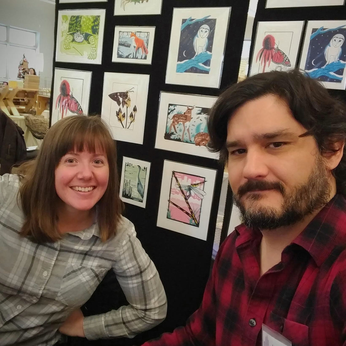 David and Jennie in front of a display of their screen print artwork.