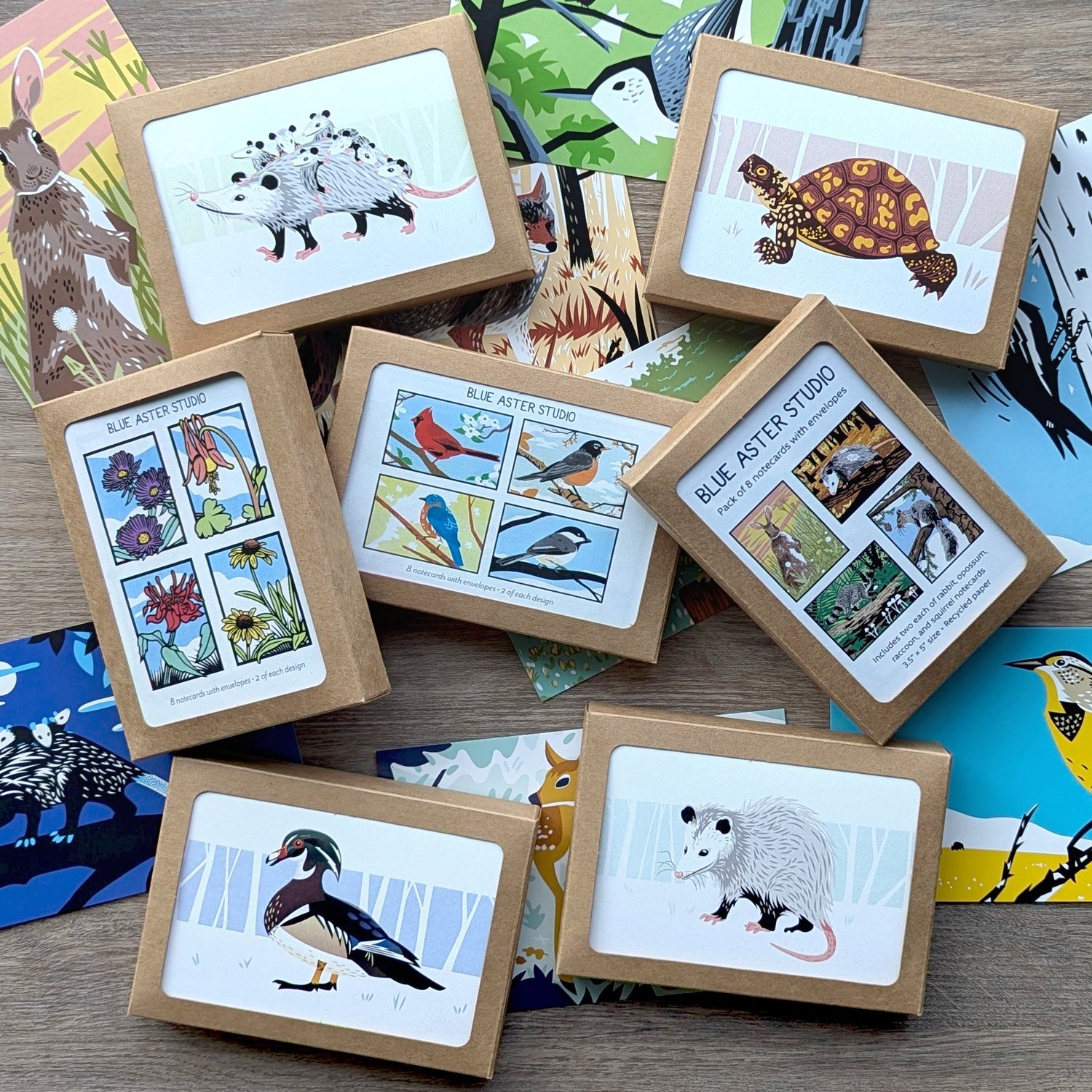 An assortment of notecard sets and individual postcards featuring illustrations of wildlife and native plants.