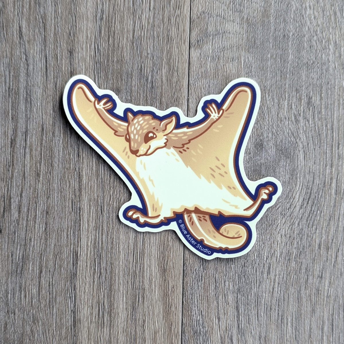 A sticker of a flying squirrel with arms and legs oustretched in a gliding posture.