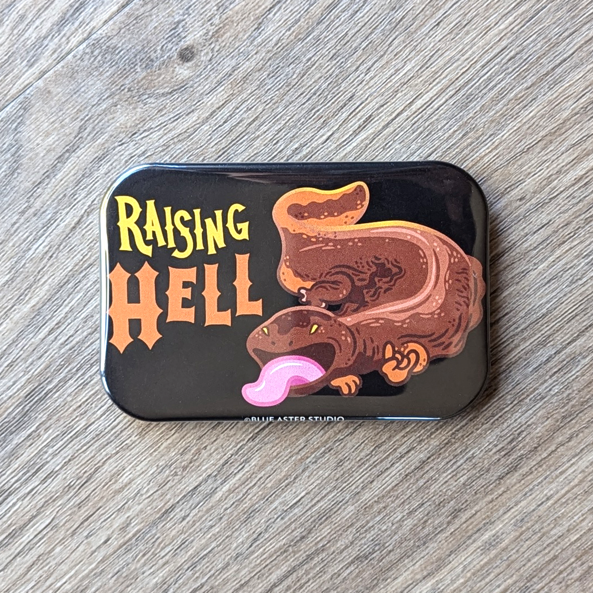 A two inch by three inch rectangular refrigerator magnet with a hellbender illustration and the text Raising Hell.