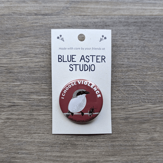 A 1.5 inch pinback button featuring an illustration of a shrike sitting on a barbed-wire with a beetle skewered with the words "I choose violence" above it.