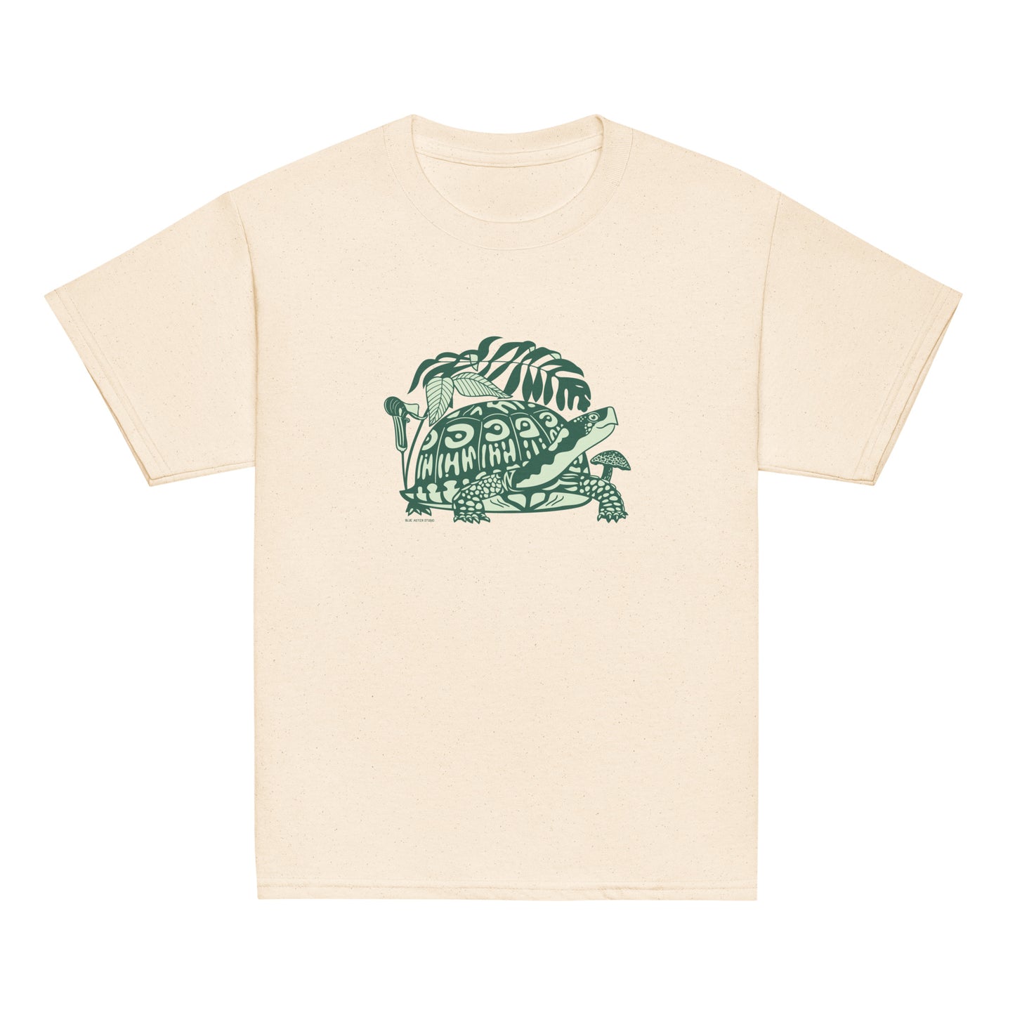 An off-white youth-sized t-shirt with a design of a happy box turtle surrounded by native North American woodland plants.