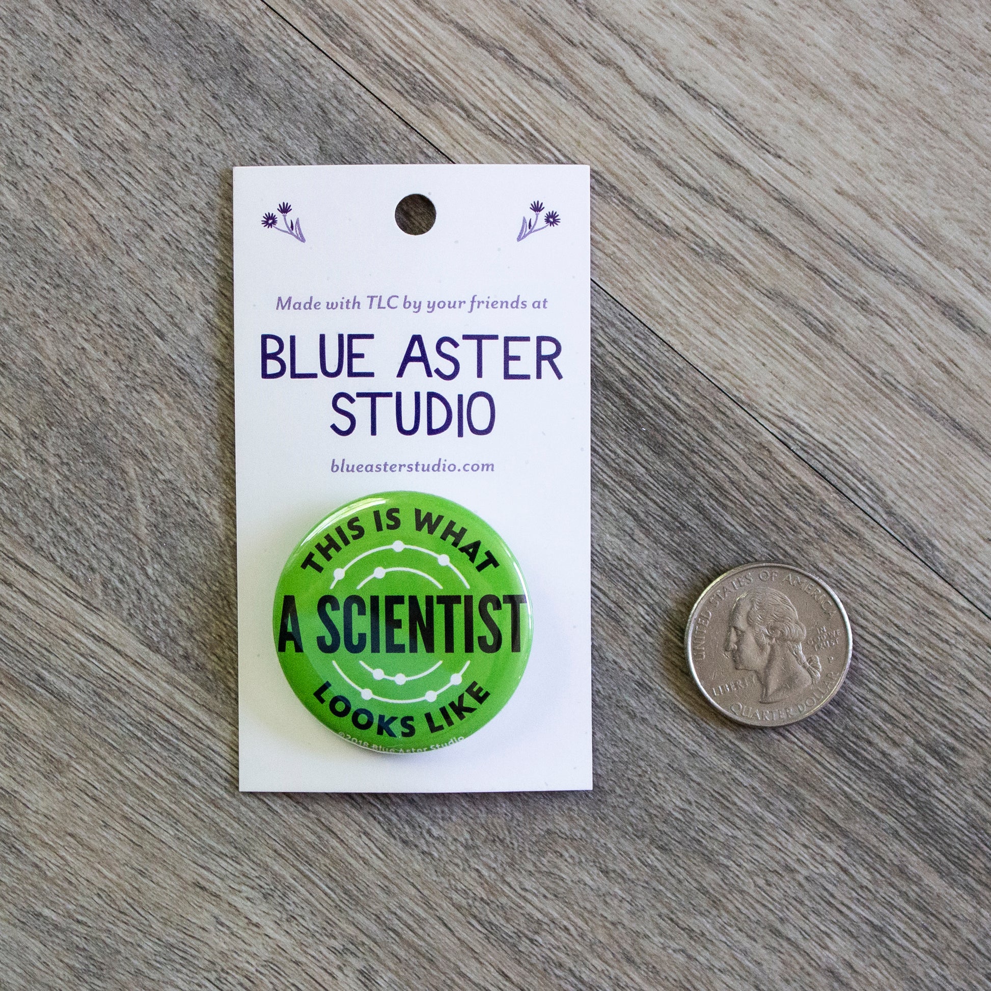 A 1.5 inch black pinback button with the words This Is What A Scientist Looks Like in white.