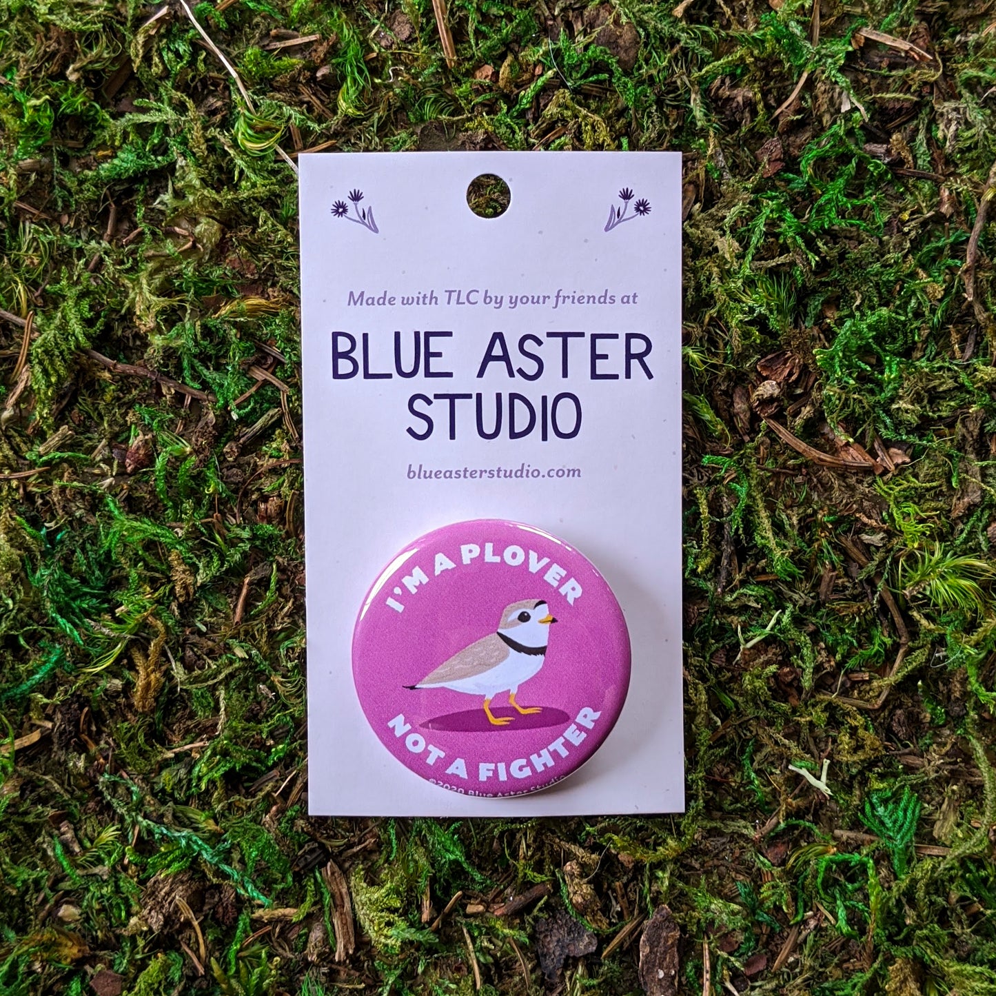 A 1.5" button with an illustration of a piping plover on a pink background with the words "I'm A Plover Not A Fighter"