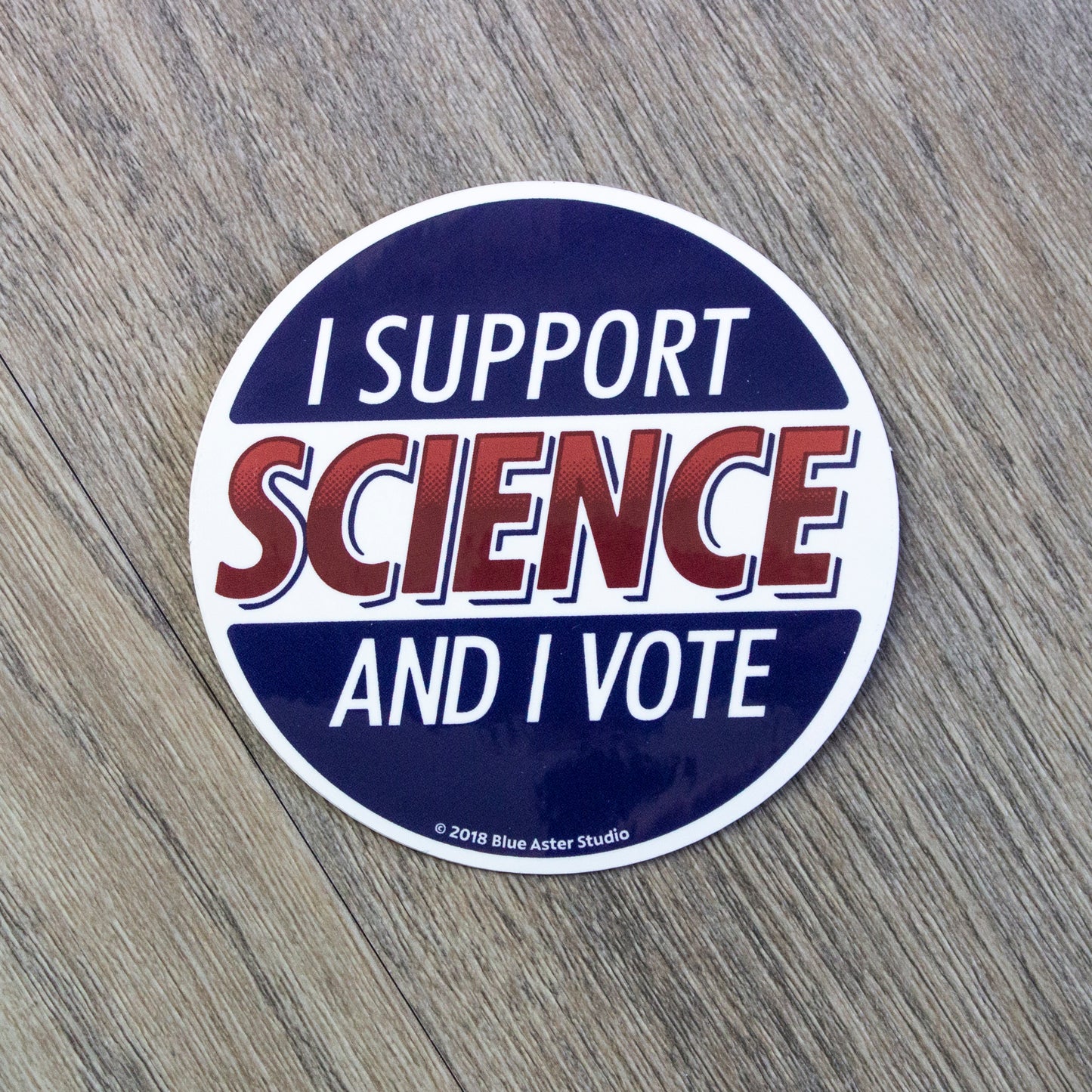 A round red white and blue vinyl sticker with the words I Support Science And I Vote