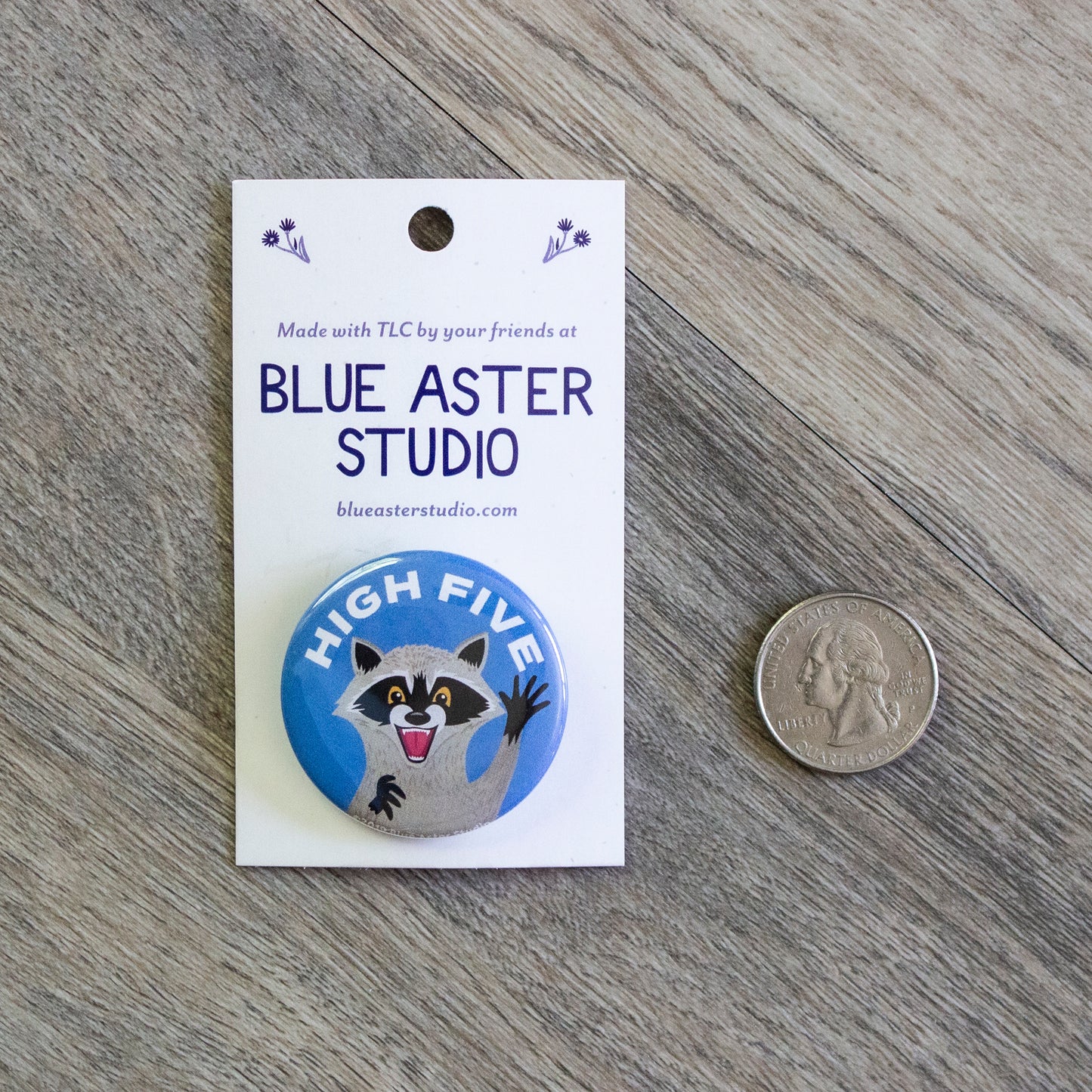 The 1.5 inch raccoon button next to a USD quarter for scale