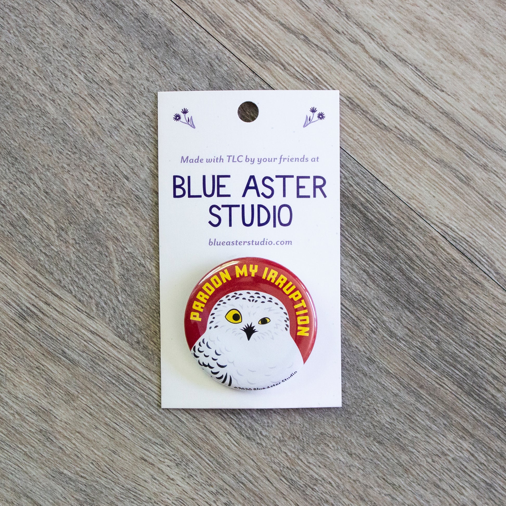 A 1.5 inch button with an illustration of a snowy owl and the words "Pardon My Irruption"