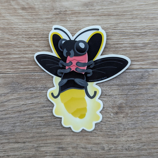 A vinyl sticker of a cartoony illustration of a lightning bug flying and lighting up.