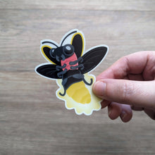 Load image into Gallery viewer, A hand holding the glow in the dark lightning bug sticker.