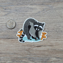 Load image into Gallery viewer, The raccoon vinyl sticker sitting next to a USD quarter for scale.