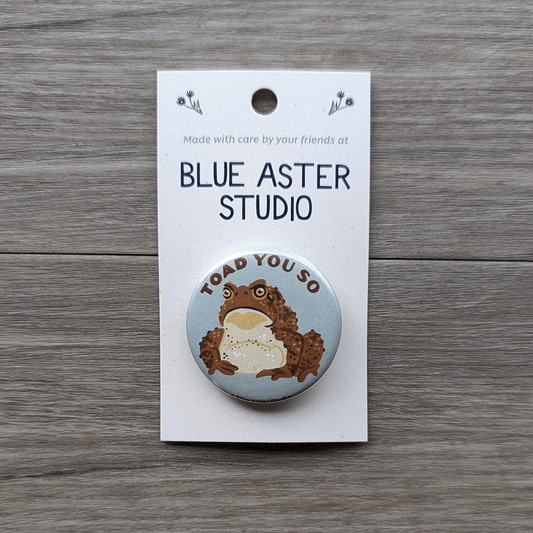 A 1.5 inch pinback button which features an illustration of a toad with the words Toad You So above it.