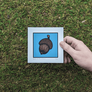A hand holding the acorn screen print to show scale.