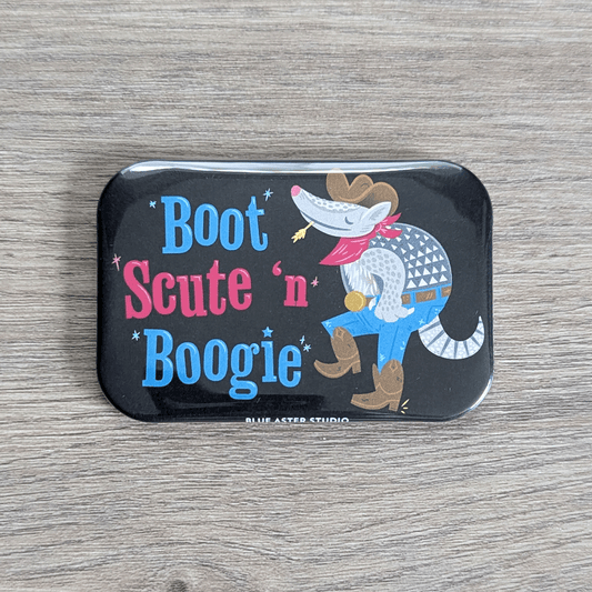 A rounded rectangular magnet featuring an illustration of a cartoony armadillo in jeans, boots, cowboy hat, and bandana dancing. Next to it is the text Boot Scute and Boogie.