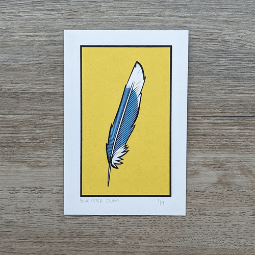 An original screen print of an illustration of a blue jay feather against a yellow background.