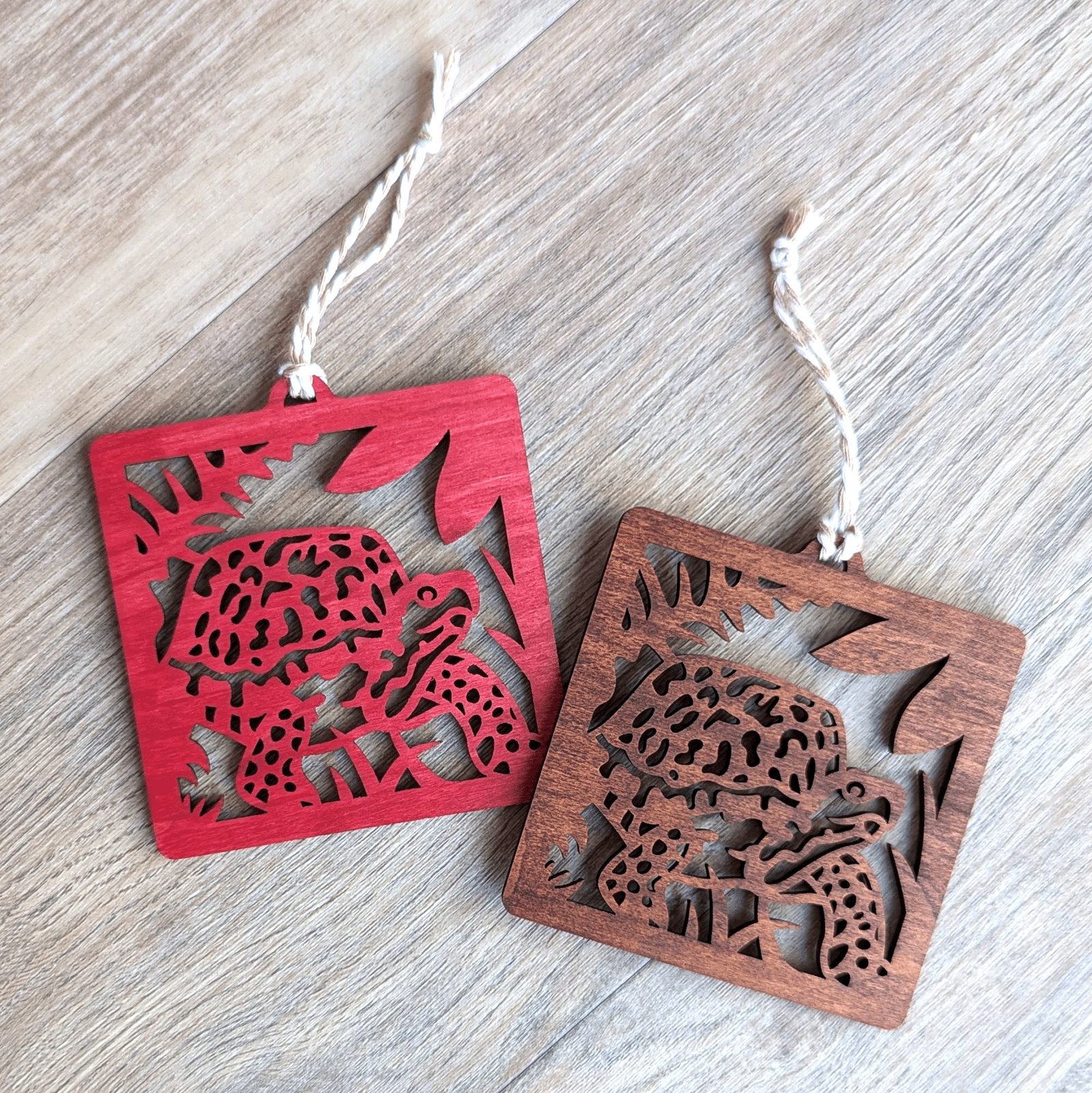 A red and a brown wooden laser cut ornament of a box turtle.