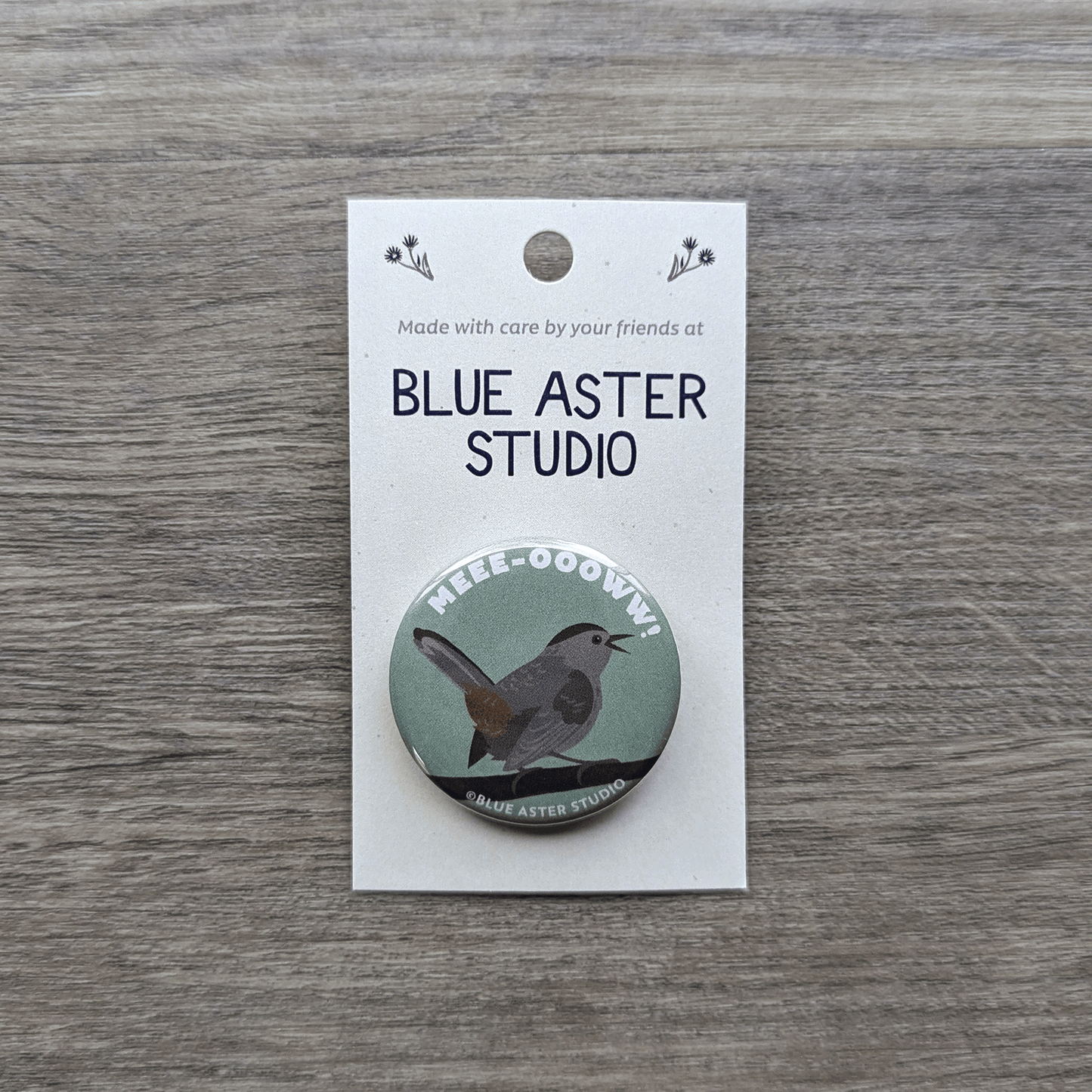 A 1.5 inch pinback button featuring an illustration of a catbird with the word meow above it.