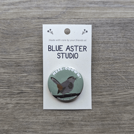 A 1.5 inch pinback button featuring an illustration of a catbird with the word meow above it.