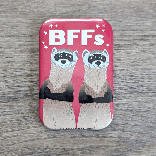 A rounded rectangle magnet featuring an illustration of two black-footed ferrets standing back to back and smiling with the text BFFs above them.