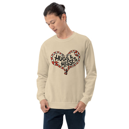 A male model wearing a tan sweatshirt with a pair of illustrated corn snakes forming a heart around the text "Hugs and Hisses"
