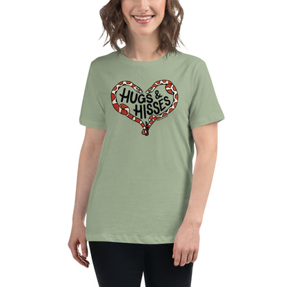 A woman wearing a sage green t-shirt with a pair of illustrated corn snakes forming a heart around the text "Hugs and Hisses"
