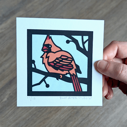 Hand holding mini cardinal screen print.