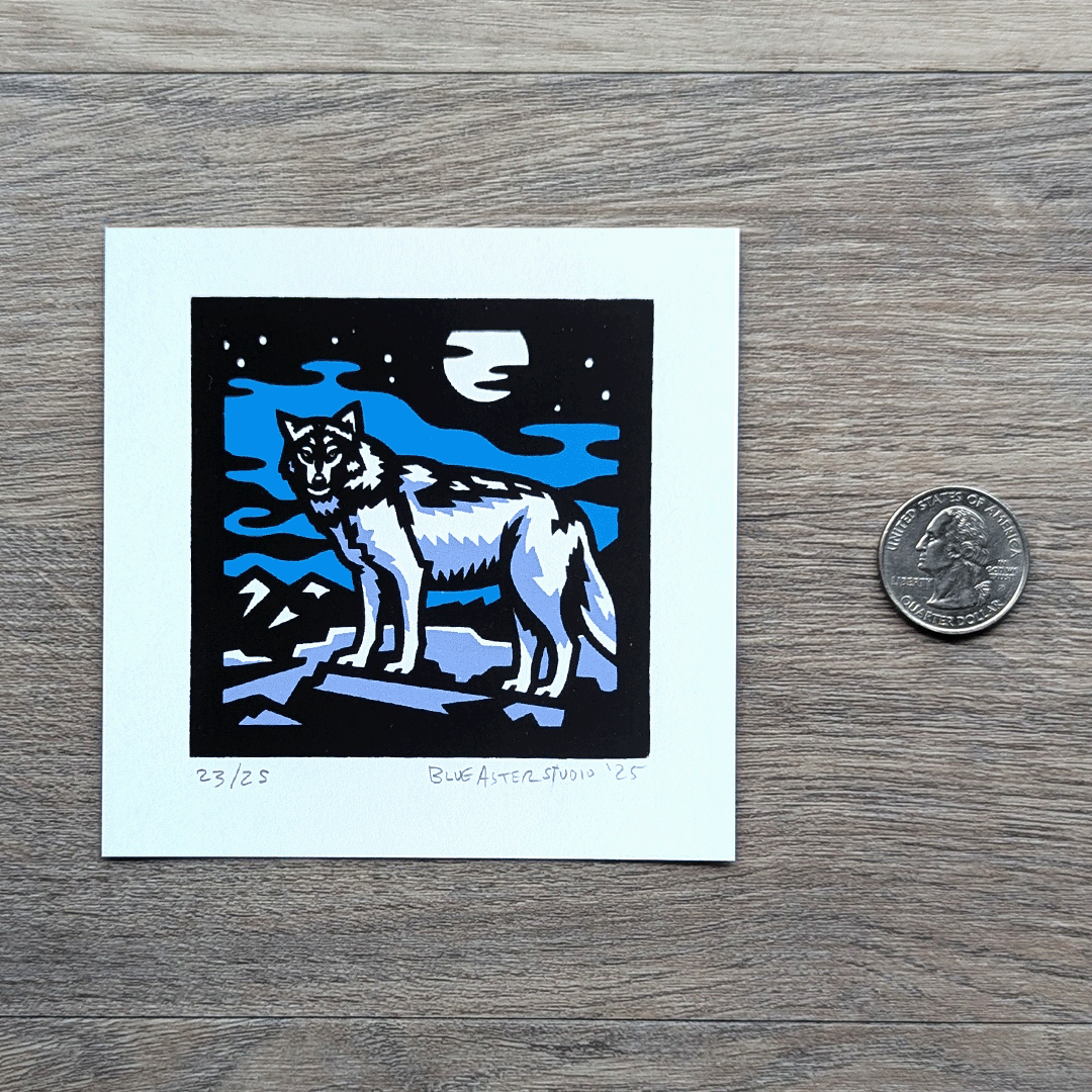 A square screen printed artwork of a gray wolf standing on a flat rock with mountains in the distance. A full moon shines above. A USD quarter is included to show the size of the four inch square print.