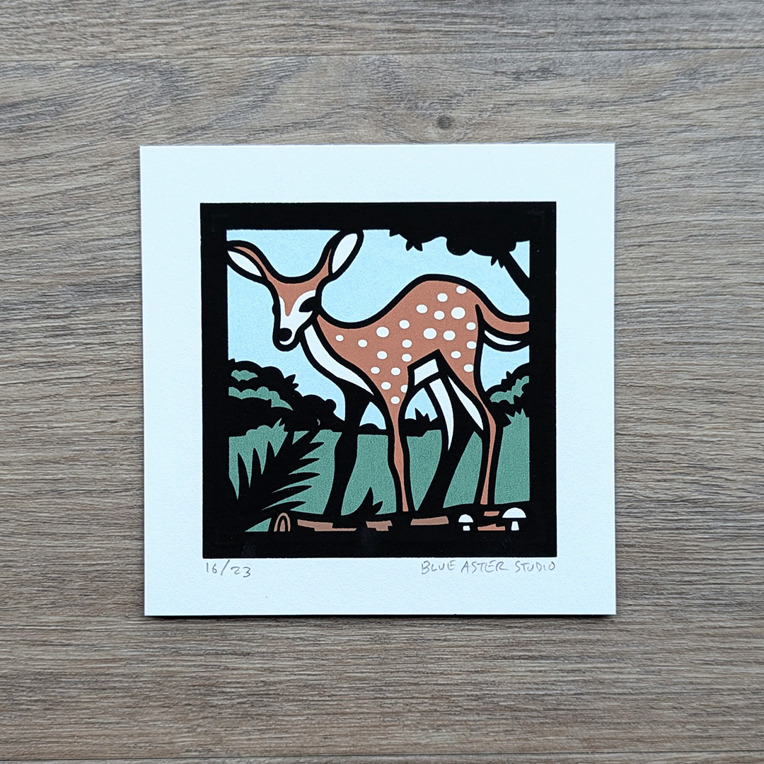 A small 4x4 inch screen print of a fawn standing near a log. Printed in four colors of blue, green, brown, and black.