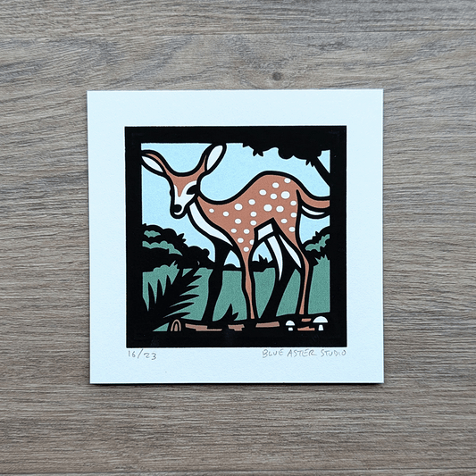 A small 4x4 inch screen print of a fawn standing near a log. Printed in four colors of blue, green, brown, and black.