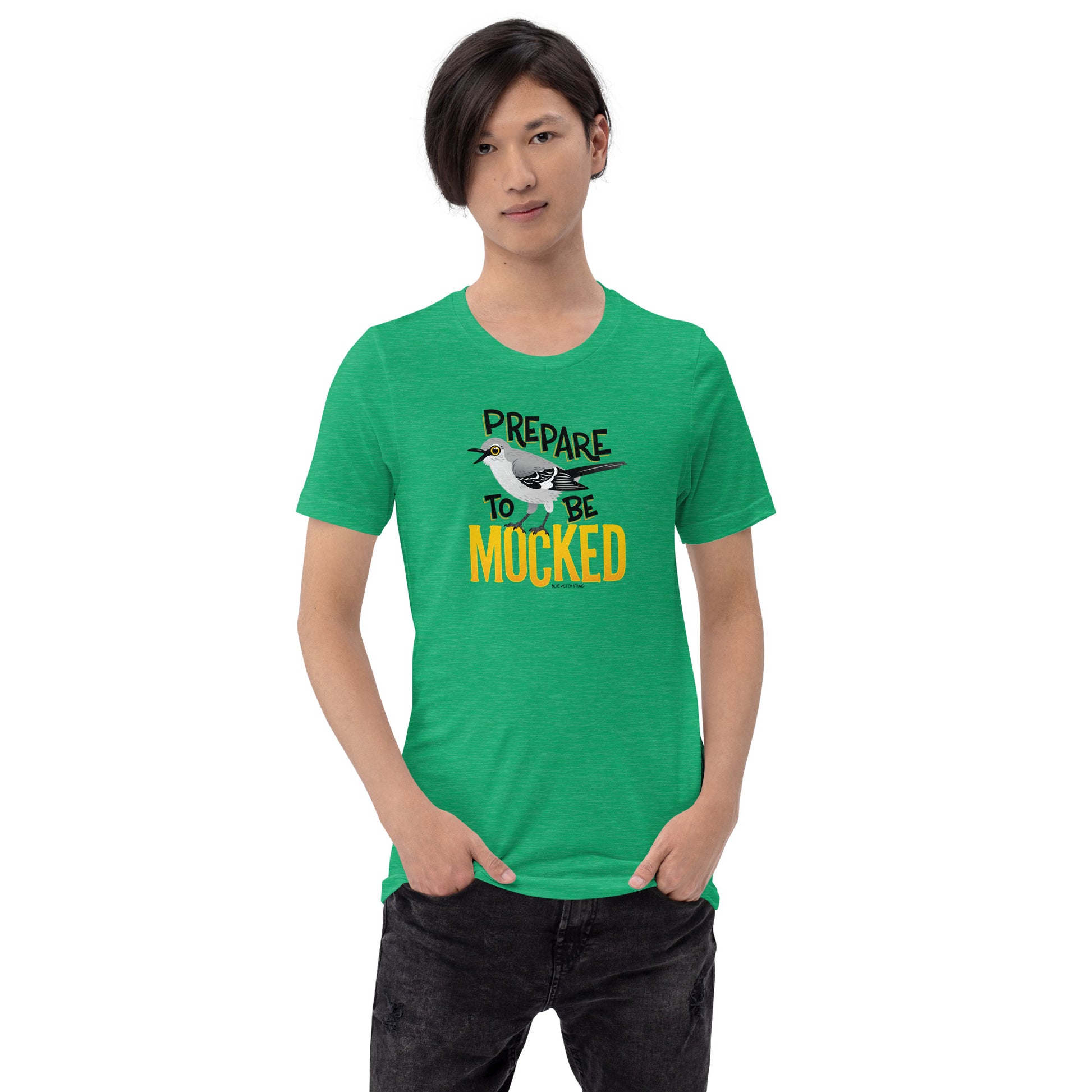 A green tee shirt worn by a male model with the text "prepare to be mocked" with an illustrated mockingbird perched within it