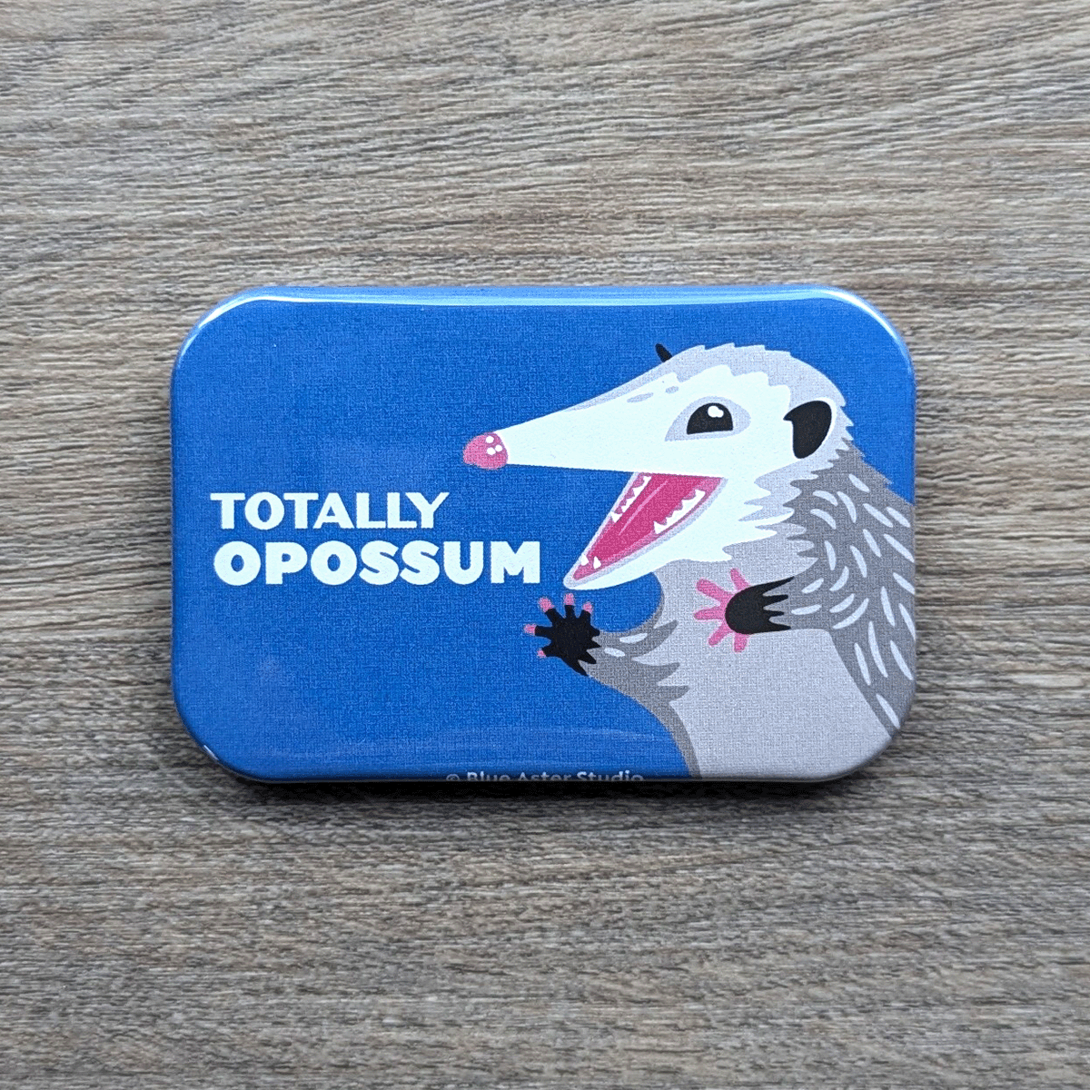 A 2 inch by 3 inch refrigerator magnet which features an illustration of an opossum and the words Totally Opossum