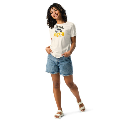A creme women's cut tee shirt worn by a dark skinned female model, with the text "prepare to be mocked" with an illustrated mockingbird perched within it