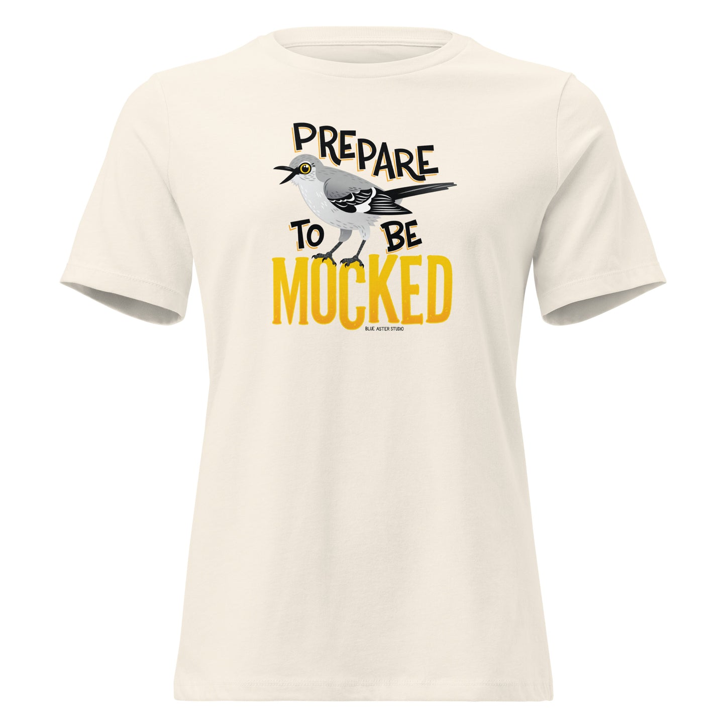 A creme women's cut tee shirt with the text "prepare to be mocked" with an illustrated mockingbird perched within it