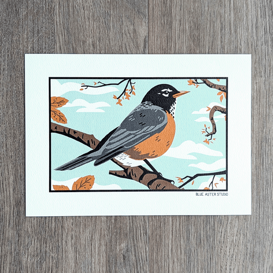 An illustration of an American robin perched on a branch with orange leaves around it