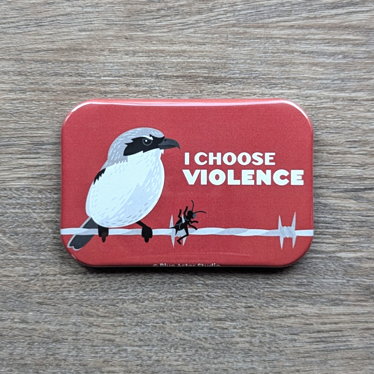 A 2x3 inch loggerhead shrike magnet which features an illustration of the bird and the words I Choose Violence.