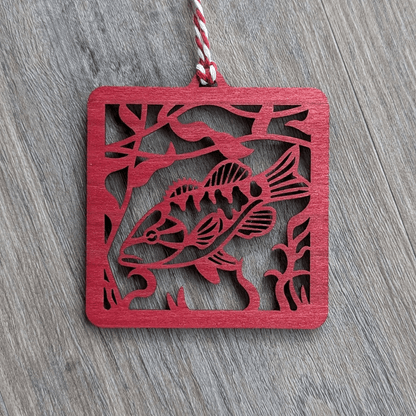 A square red wooden ornament of a smallmouth bass.
