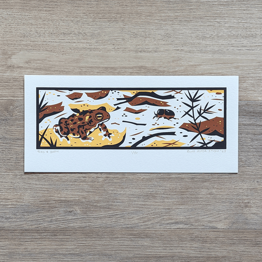 A screen printed illustration of an american toad sitting on a fallen leaf, surrounded by forest litter and a black rhinoceros beetle.