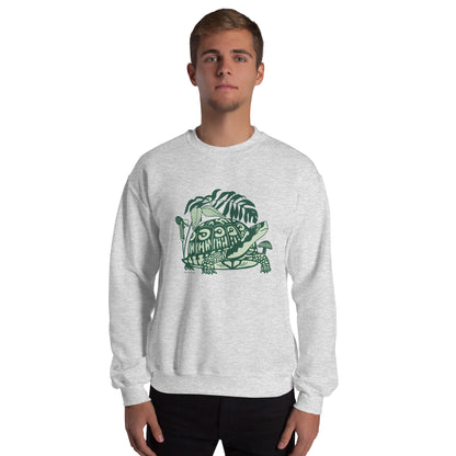 A man wearing a light gray crew neck sweatshirt with a design of a box turtle surrounded by woodland plants.