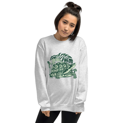 A woman wearing a light gray crew neck sweatshirt with a design of a box turtle surrounded by woodland plants.