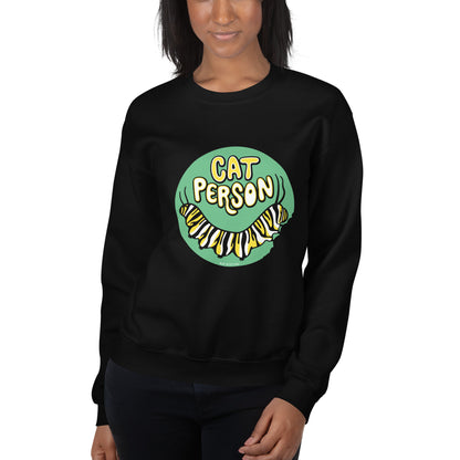 A model sporting a black sweatshirt with the cat person monarch caterpillar design on front.