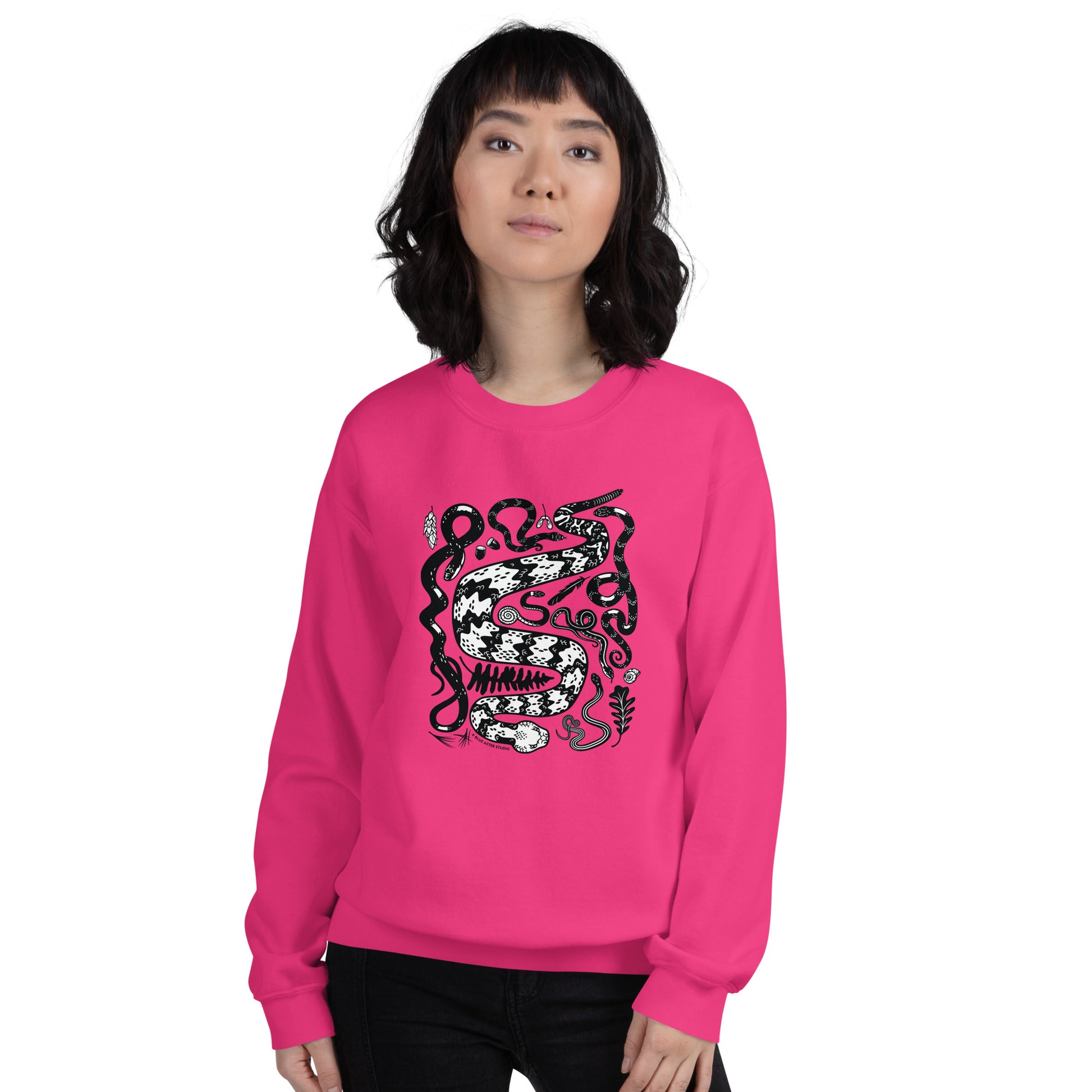 A woman wearing the unisex seven snakes sweatshirt in heliconia pink.