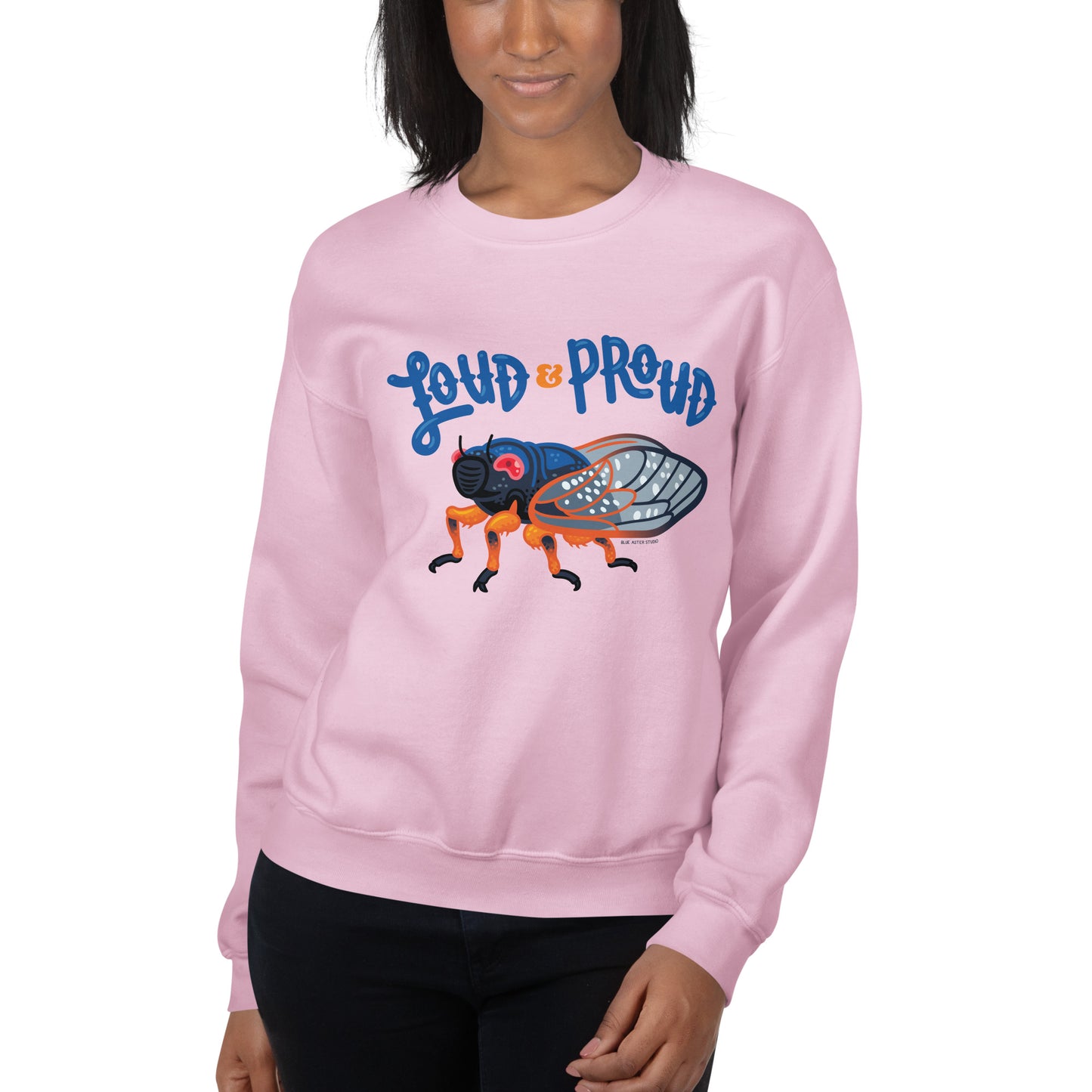 A woman showing off the loud and proud cicada sweatshirt in light pink.