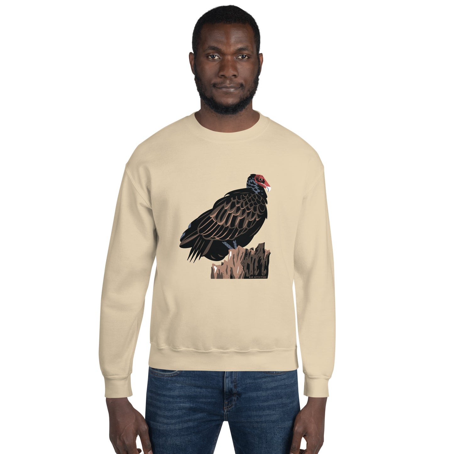 A man wearing the majestic turkey vulture sweatshirt in the sand color.