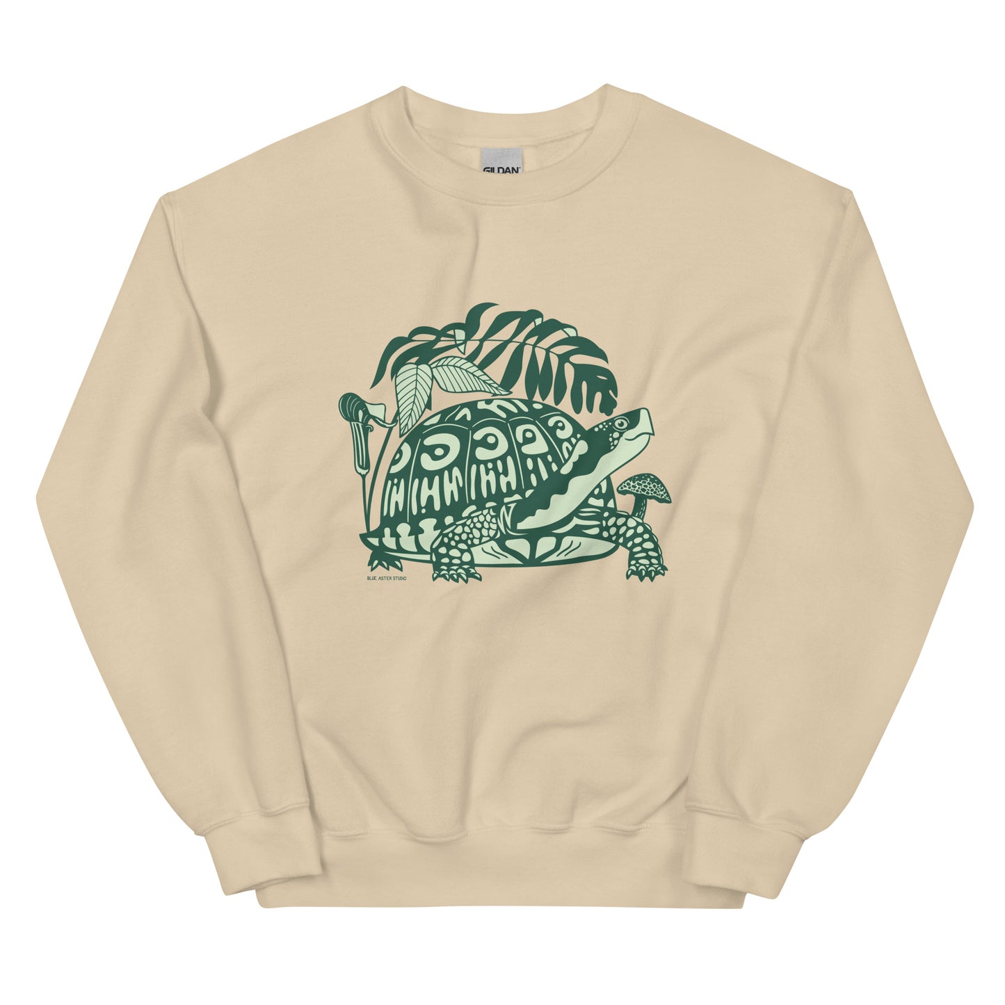 A light beige crew neck sweatshirt with a design of a box turtle surrounded by woodland plants.