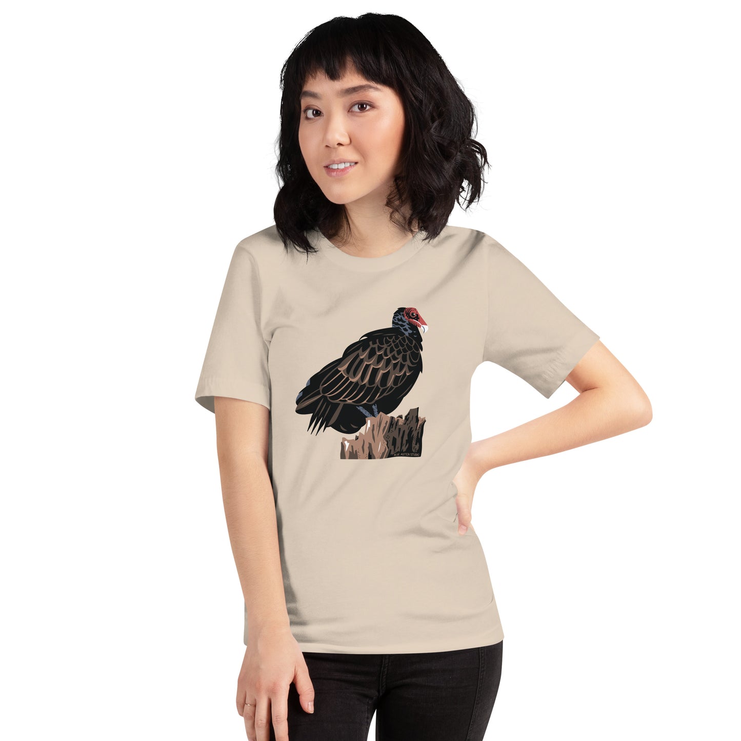 A woman wearing the cream colored majestic turkey vulture short-sleeved t-shirt.