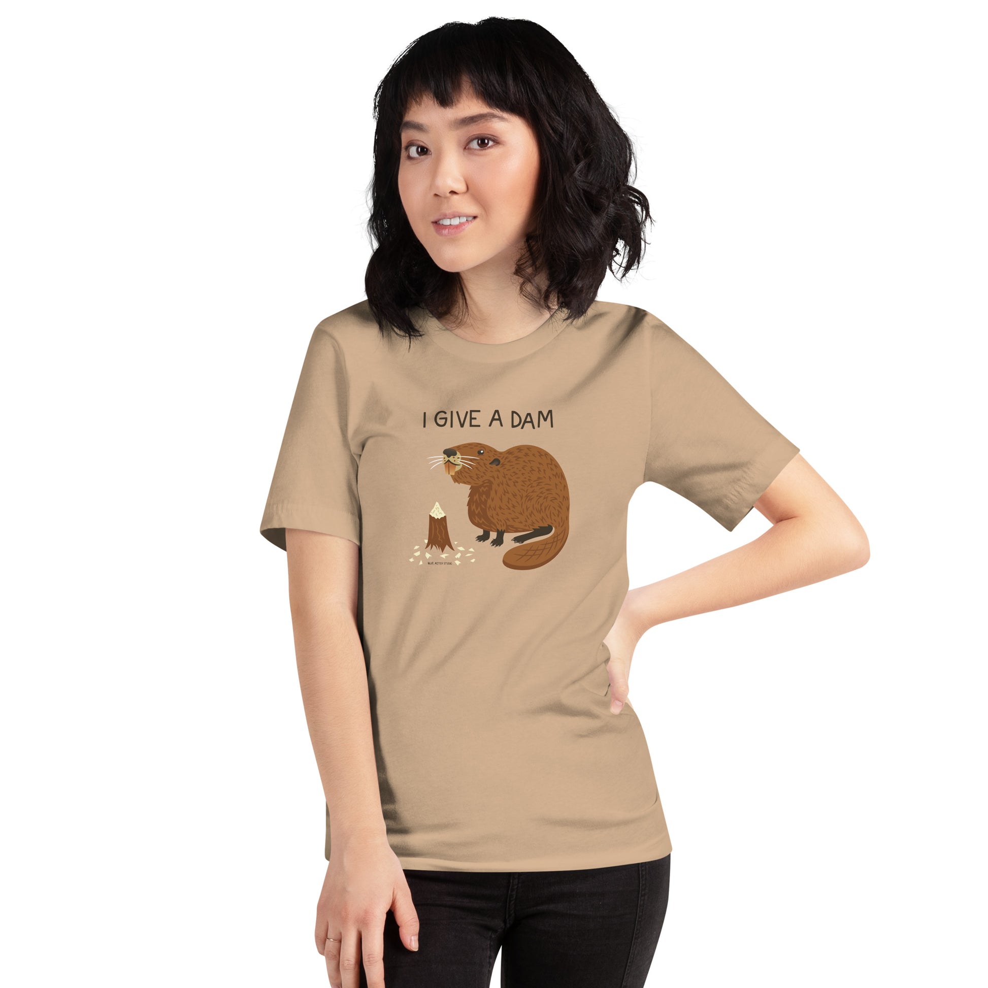 A woman modeling the unisex I Give A Dam beaver t-shirt in tan.