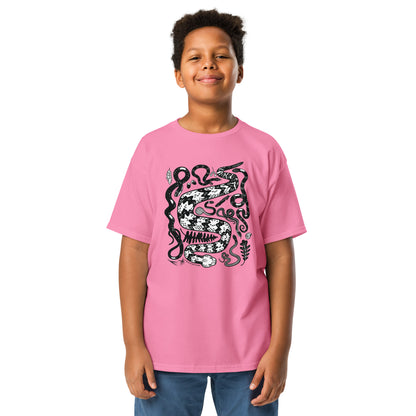 A young boy wearing a pink seven snakes tee.