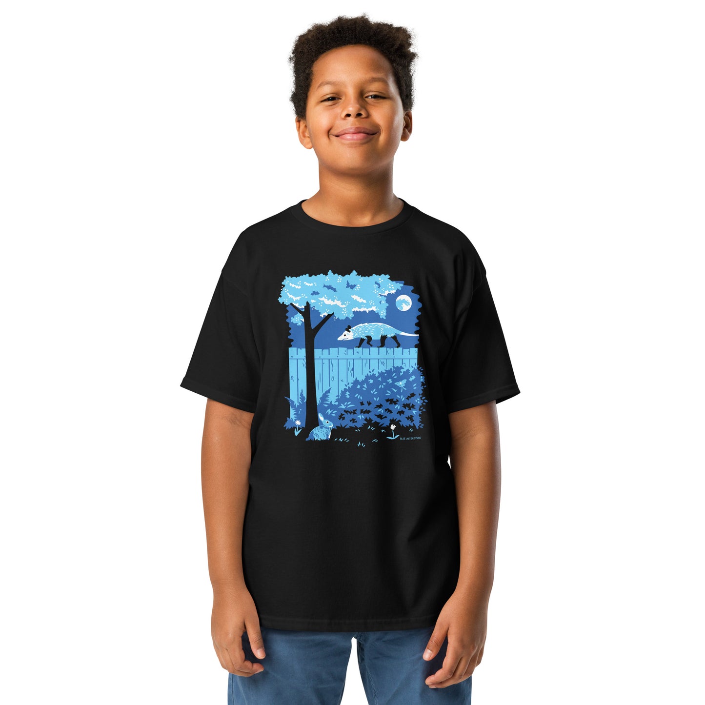 A young boy wearing the opossum and rabbit t-shirt in black.