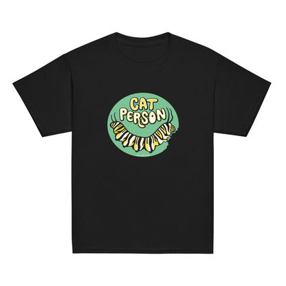 A youth sized black t-shirt with a green circular design of the text Cat Person above a monarch caterpillar, which is munching at the circle.
