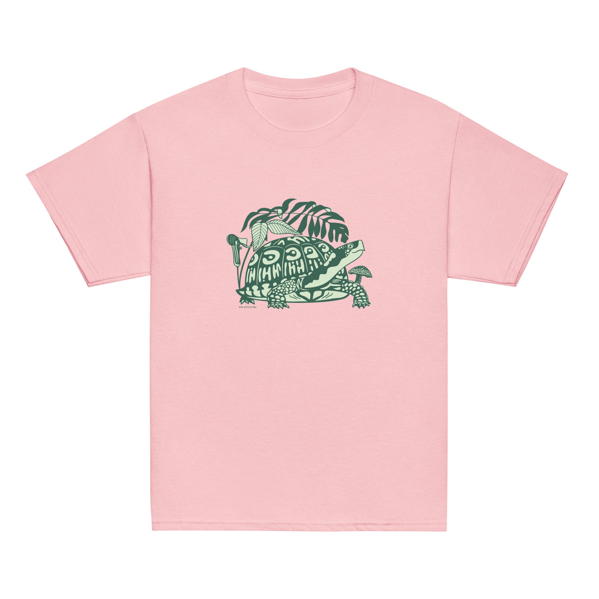 A pink youth-sized t-shirt with a design of a happy box turtle surrounded by native North American woodland plants.