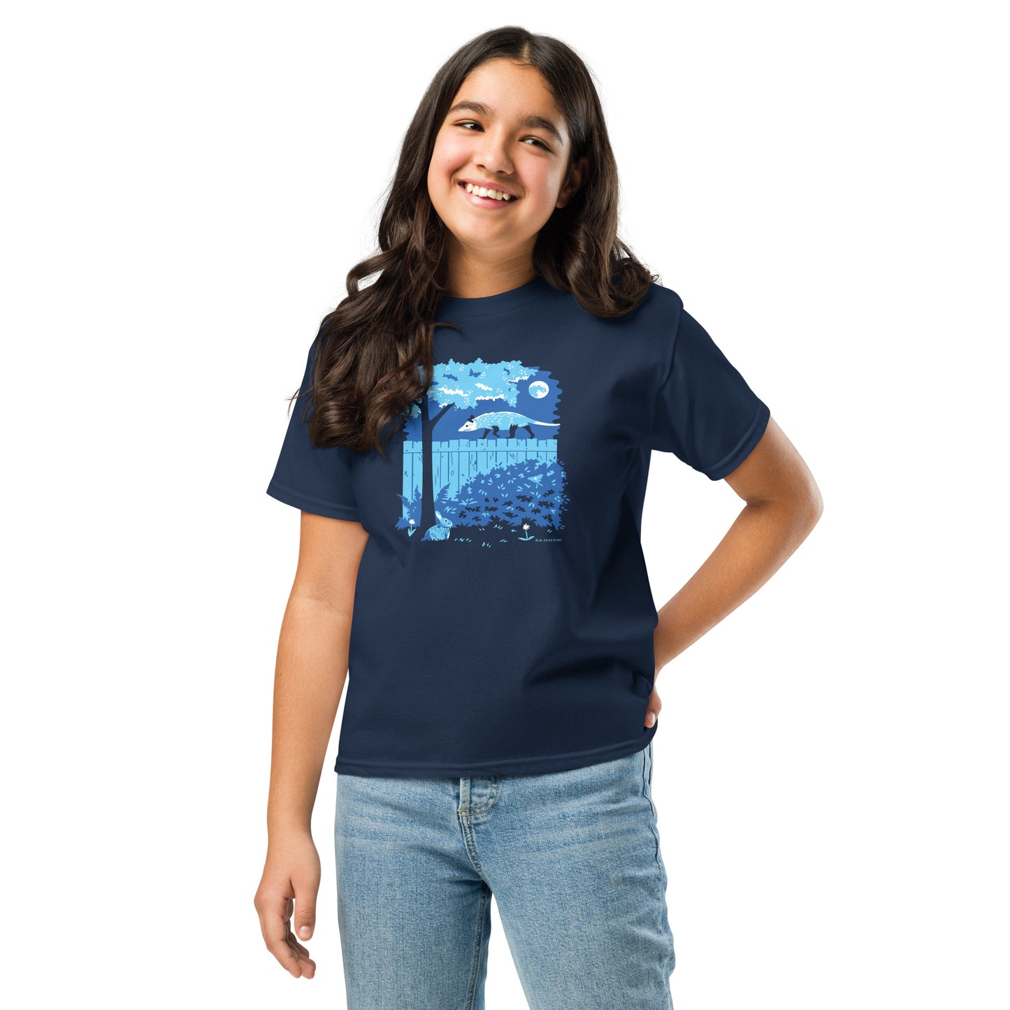 A young girl wears the opossum and rabbit shirt in navy.